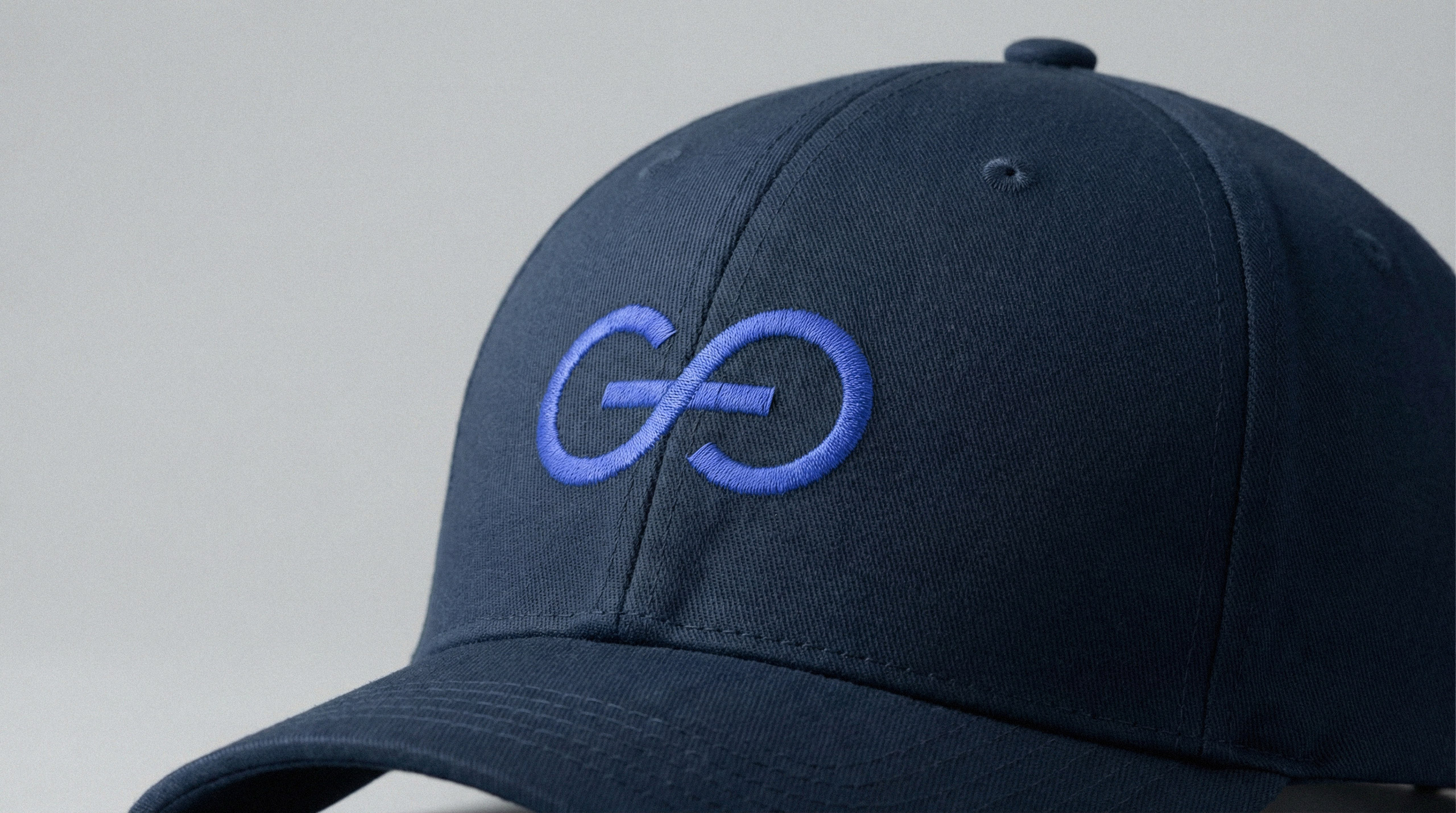 Black snapback cap photographed with embroidered GoFlow logo embroidered on front, modern brand merchandise.