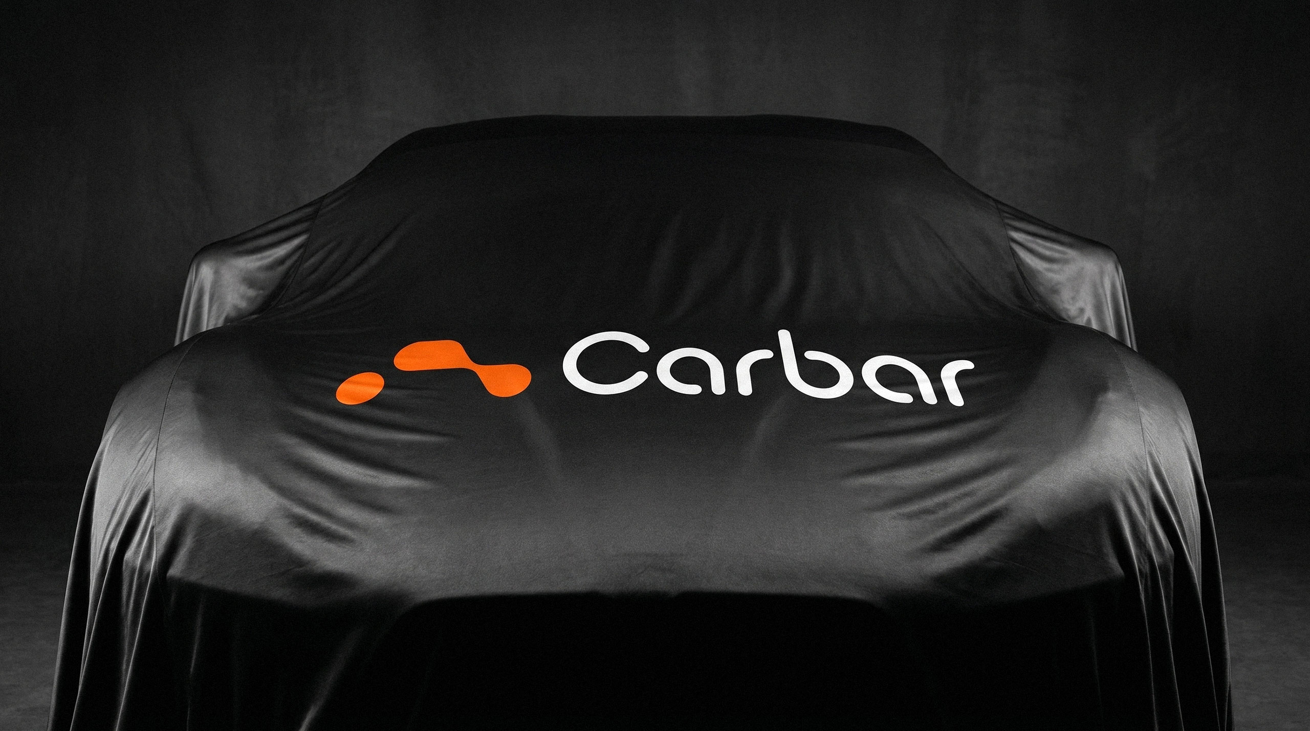 A sleek sports car hidden under a black indoor cover featuring the Carbar logo on the hood - design by Brandforma Studio.