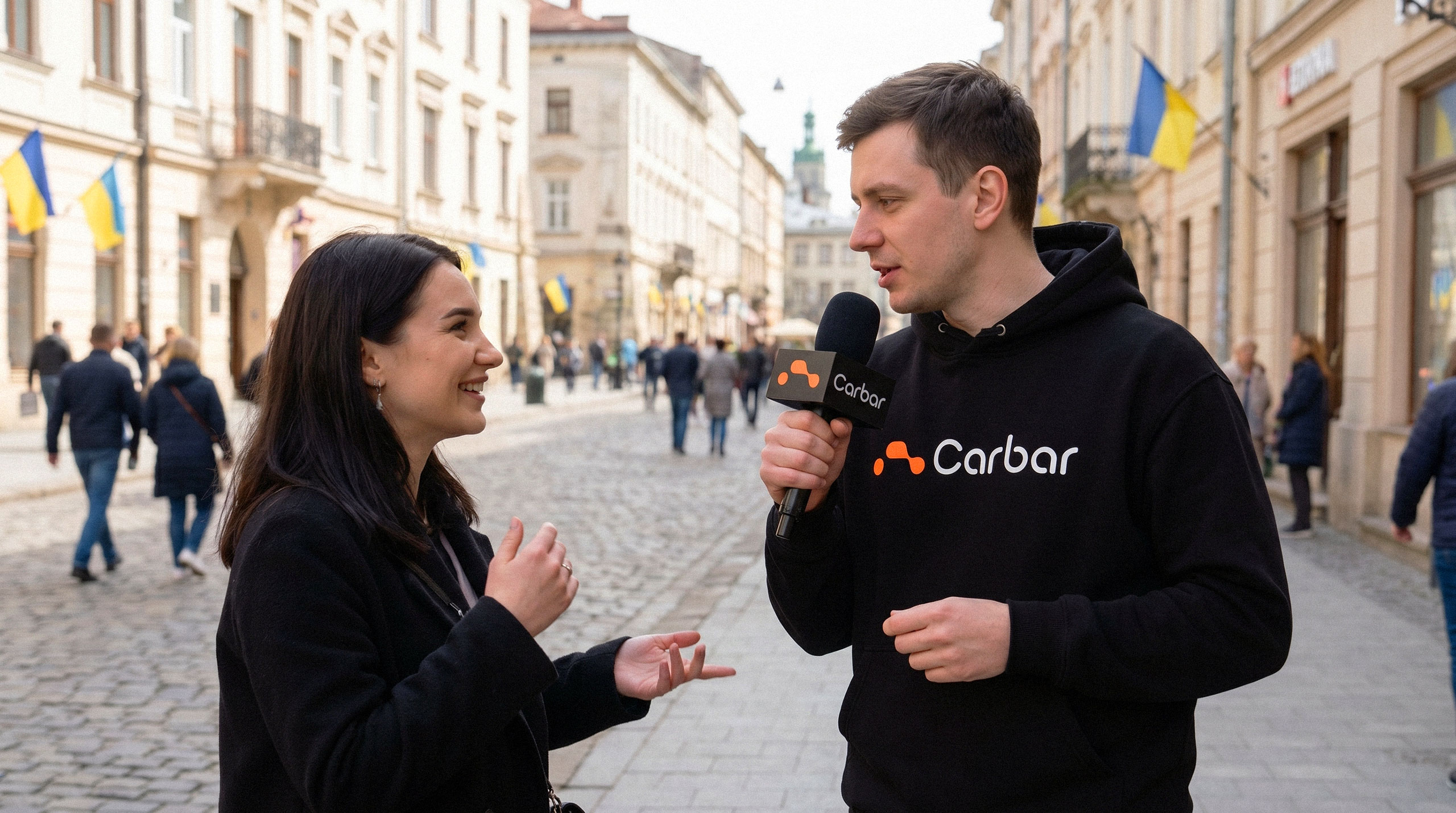 An interviewer with a Carbar branded microphone speaking to a woman on a cobblestone street - design by Brandforma Studio.