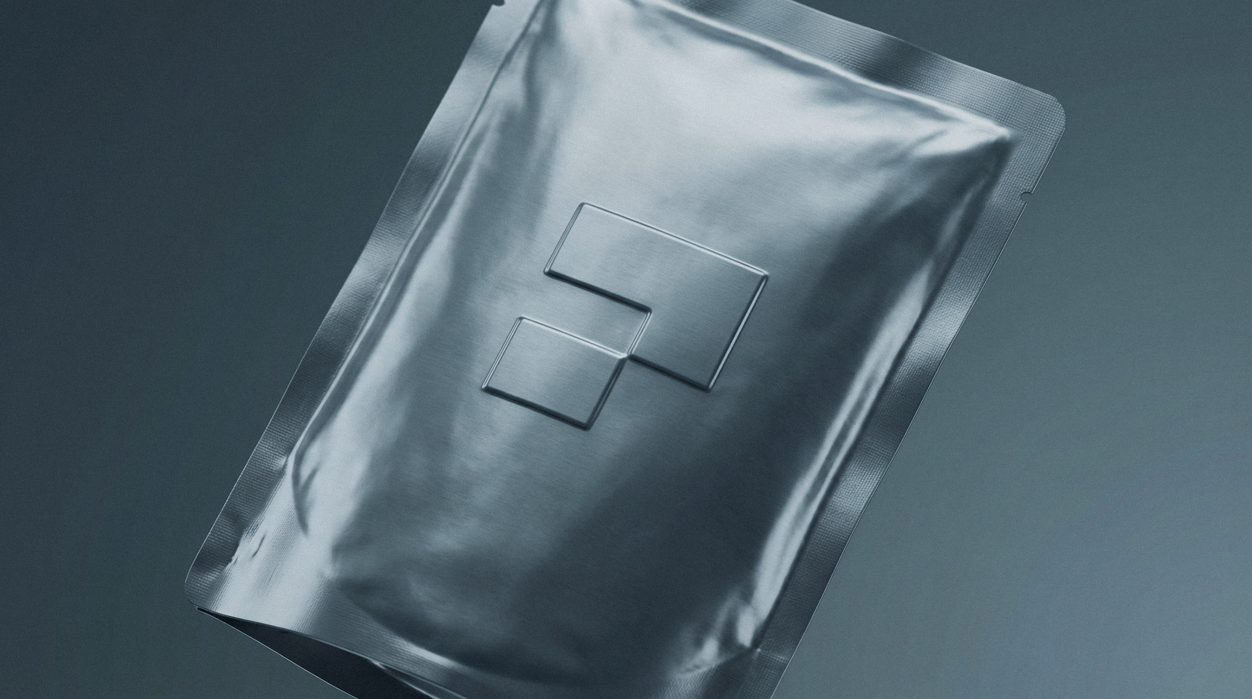 Close up of an embossed geometric logo on silver foil flexible packaging by Brandforma Studio