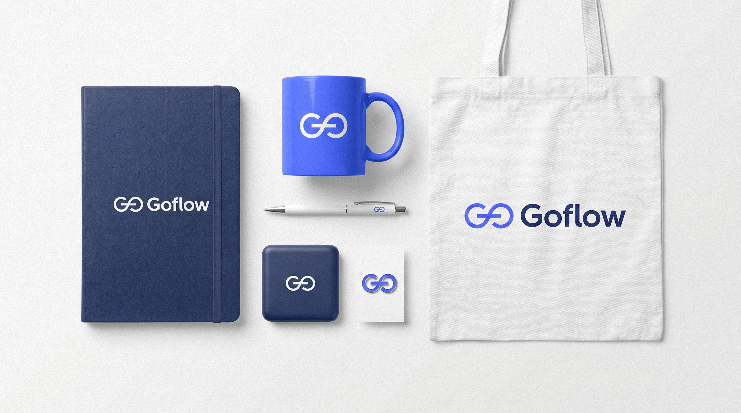 Flat lay of Goflow branded merchandise including a notebook, mug, pen, and tote bag