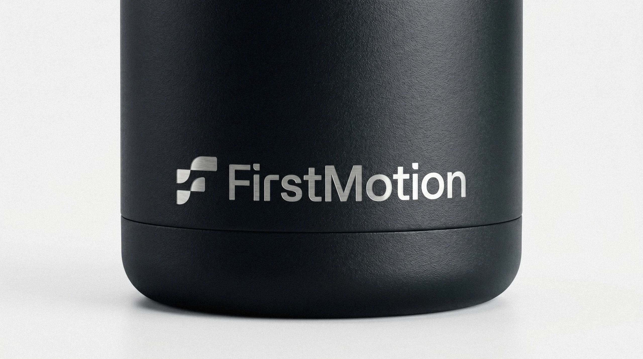 Black insulated FirstMotion tumbler with white logo