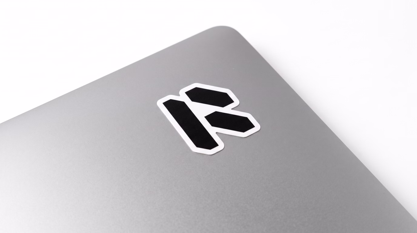Black Modern Tech R logo printed as a die-cut sticker applied to a silver laptop.